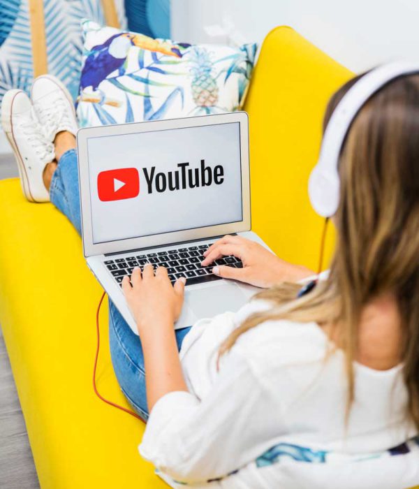 Woman using laptop with YouTube screen